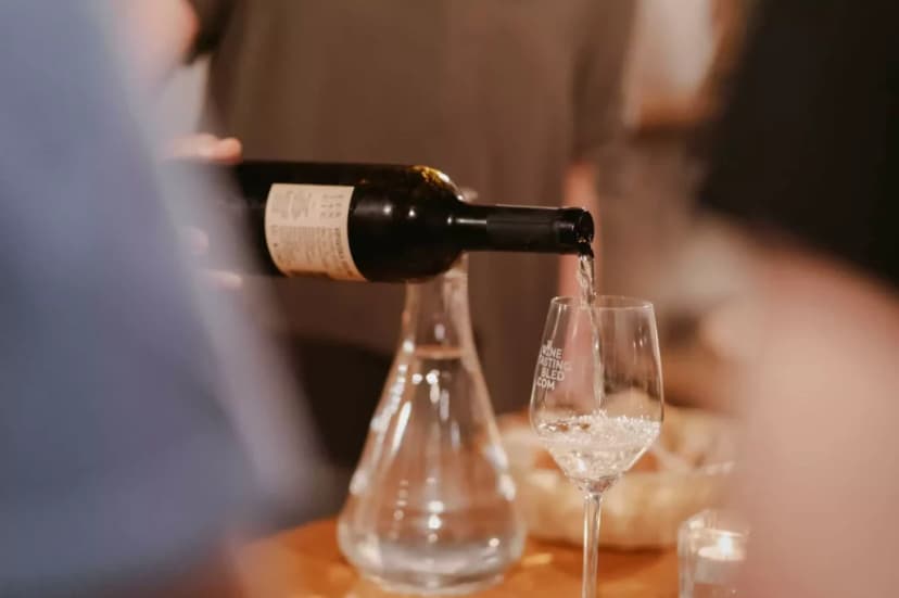 Wine being poured from a bottle into a glass during a tasting event in Bled, Slovenia.