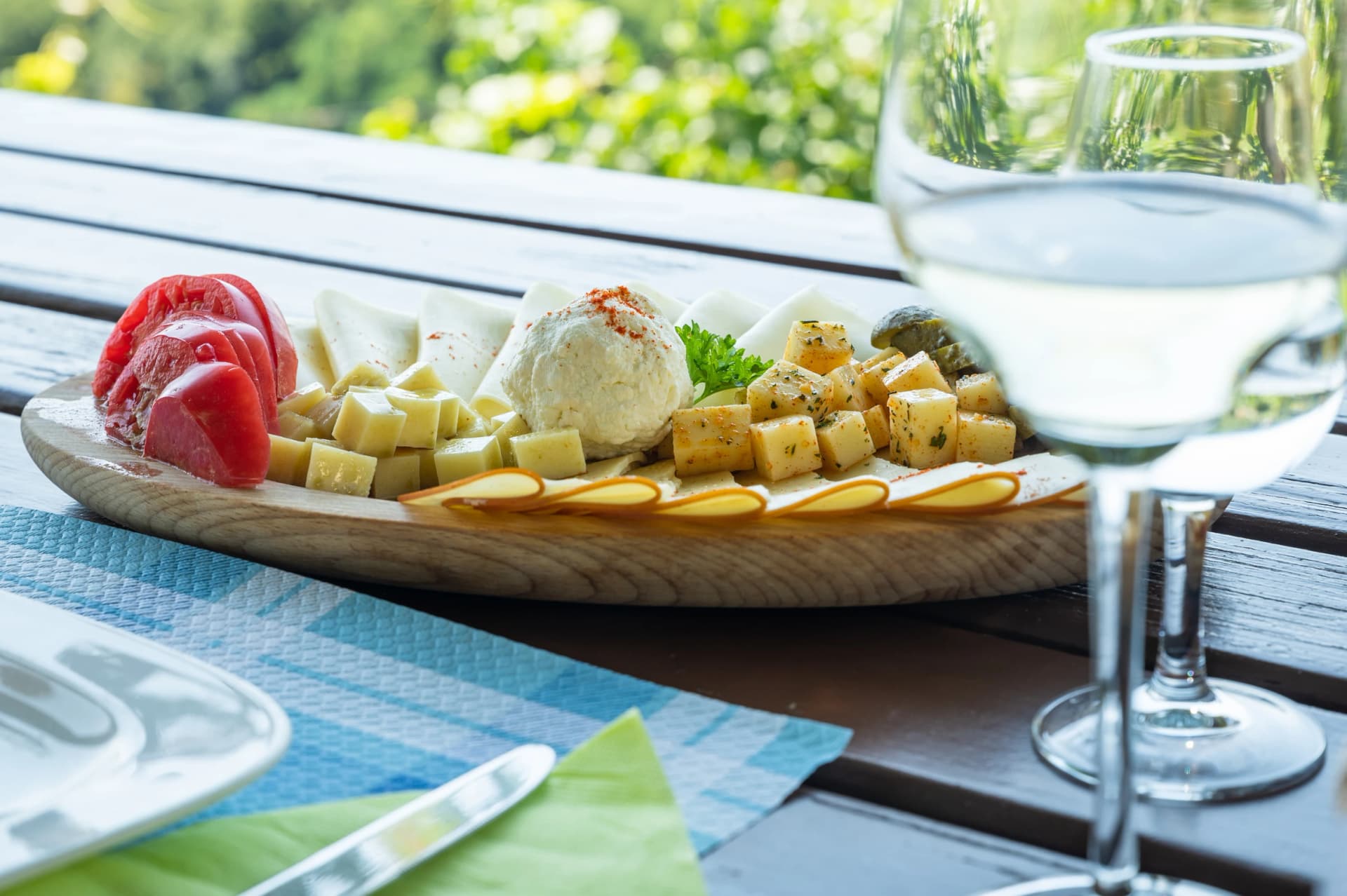 Homemade cheese platter and white wine in a wine tavern in the Slovenian vineyards
