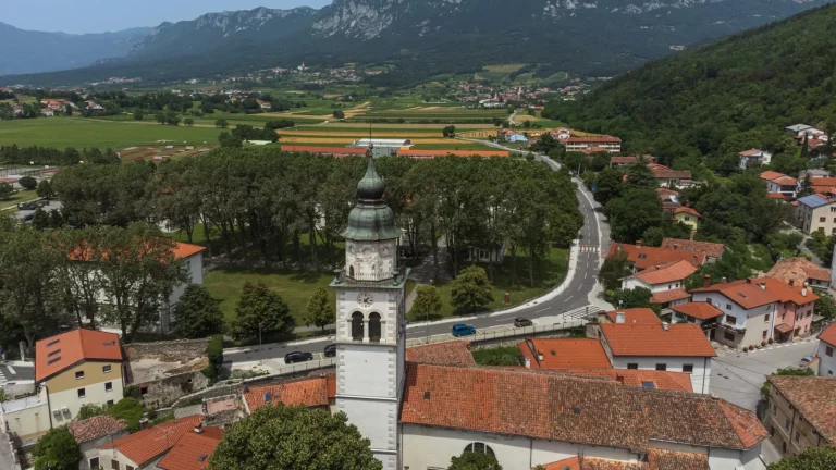 Aerial View of Vipava Town, Slovenia. Red Roofs, Church, Fields and Forest Covered Hills in the Background